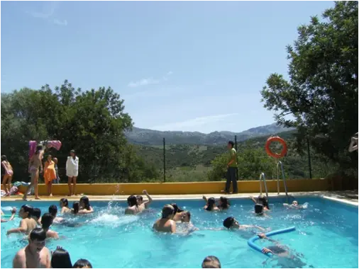 Niños y adolescentes en una piscina en las montañas